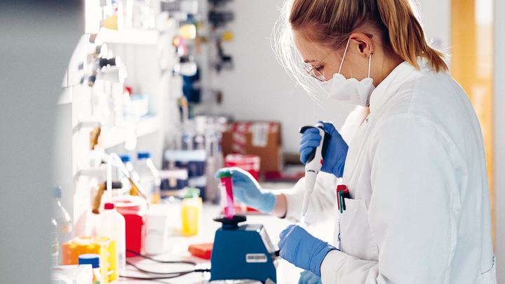Eine Person in weißem Kittel im Labor der Apparativen Biotechnologie